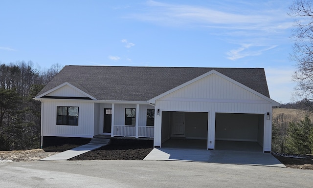 view of front facade featuring a garage, a porch, concrete driveway, and roof with shingles