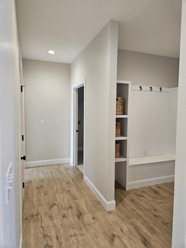 hallway with recessed lighting, baseboards, and light wood finished floors