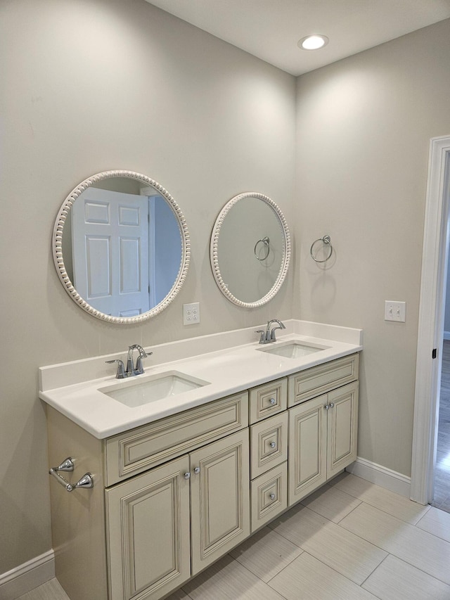 bathroom featuring double vanity, a sink, and baseboards