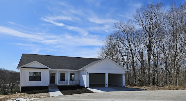 view of front of home featuring driveway, roof with shingles, and an attached garage