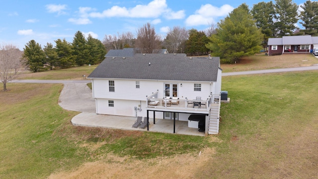 rear view of house with a yard, a wooden deck, a patio area, and central AC unit