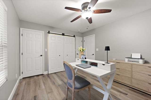 349 Sycamore Dr, Bronston, KY 42518 - office featuring light hardwood / wood-style flooring, ceiling fan, and a barn door