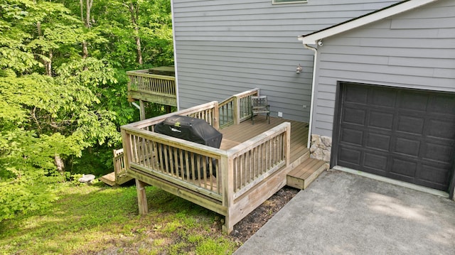 wooden terrace featuring a garage and driveway