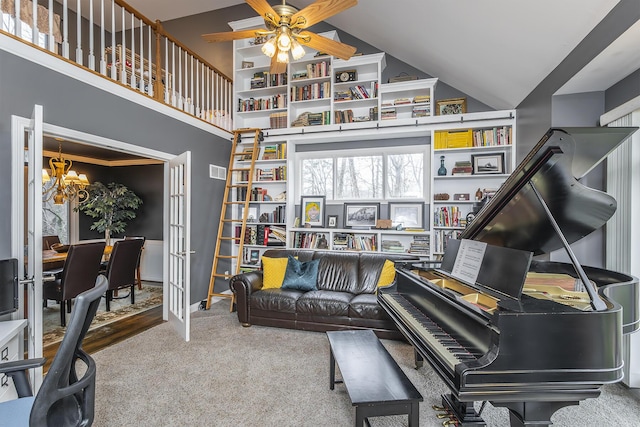 living room with a chandelier, ceiling fan, carpet floors, built in features, and a towering ceiling