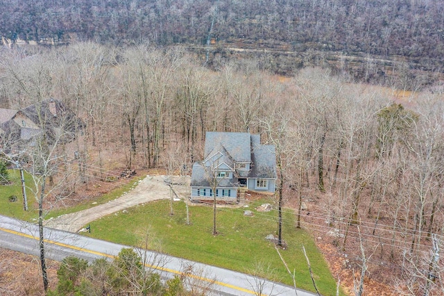 aerial view of property and surrounding area featuring a heavily wooded area
