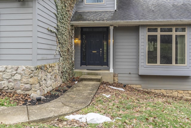 property entrance featuring a shingled roof