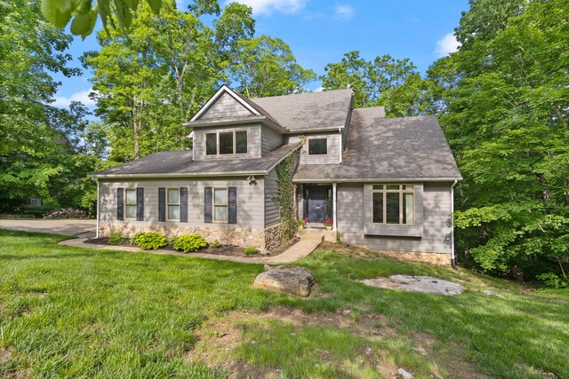 view of front facade with a front yard and stone siding