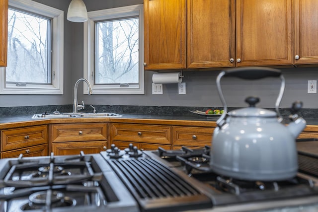 kitchen with a sink, dark countertops, and brown cabinets