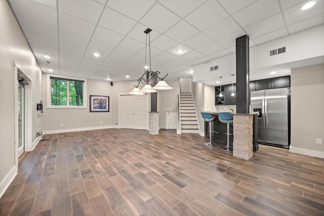 kitchen with stainless steel fridge with ice dispenser, a breakfast bar area, baseboards, light countertops, and recessed lighting
