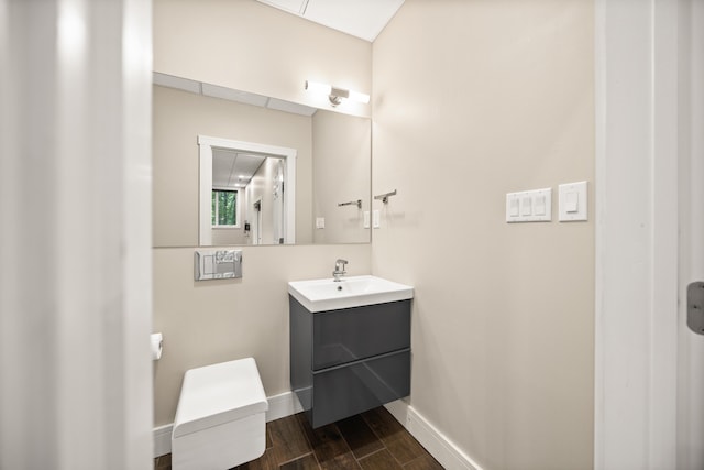 bathroom featuring baseboards, vanity, and wood finished floors