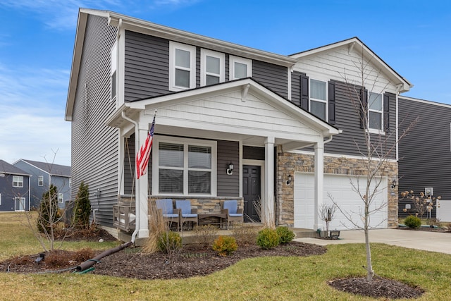 view of front of house featuring a garage, a front lawn, and covered porch