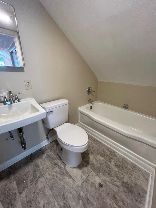 bathroom featuring a bath, vaulted ceiling, and toilet