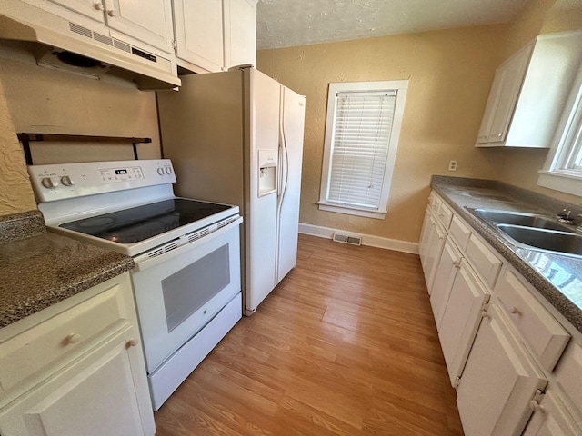 kitchen with white appliances, light wood-type flooring, and white cabinets