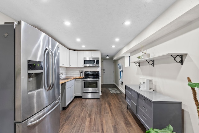 kitchen with appliances with stainless steel finishes, tasteful backsplash, butcher block counters, gray cabinetry, and white cabinets