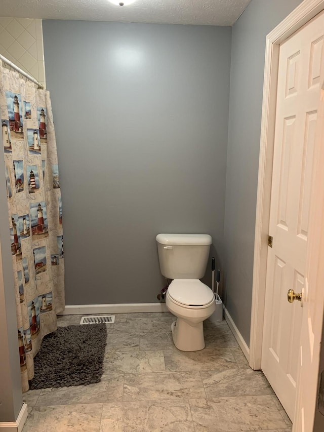 bathroom featuring toilet, curtained shower, baseboards, and visible vents