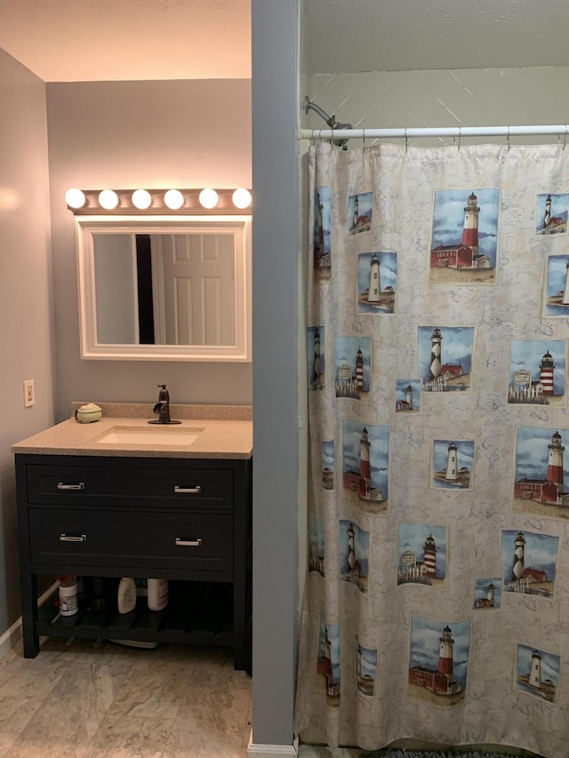 bathroom with vanity, a shower with shower curtain, and baseboards