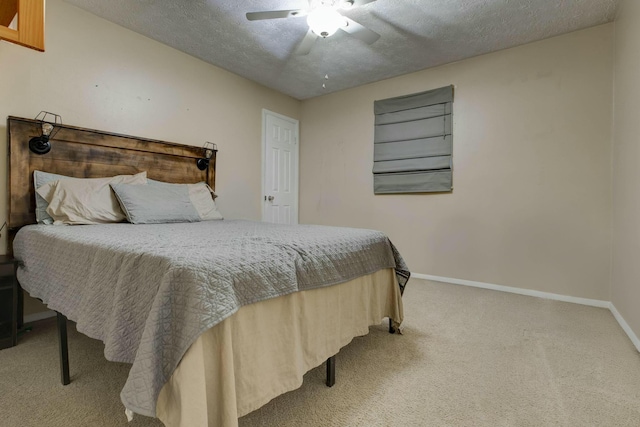 carpeted bedroom featuring ceiling fan and a textured ceiling