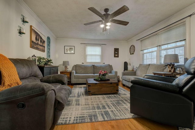 living room featuring hardwood / wood-style floors, ornamental molding, and ceiling fan