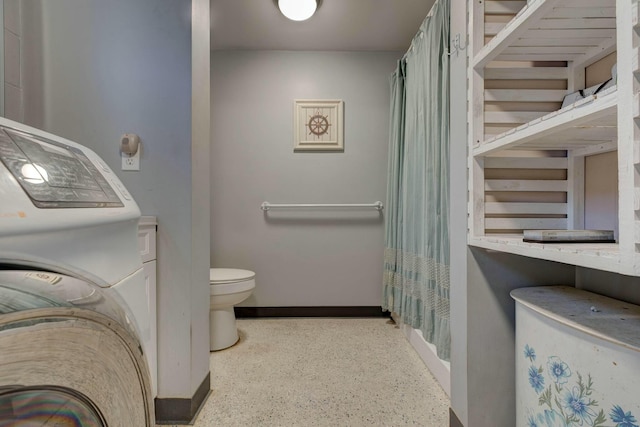 bathroom featuring toilet and washer / dryer