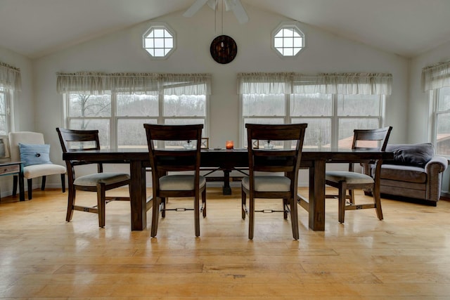 dining area with ceiling fan, lofted ceiling, and light wood-type flooring