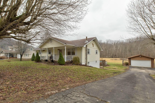 view of front of property with an outbuilding, a garage, a front yard, and a porch