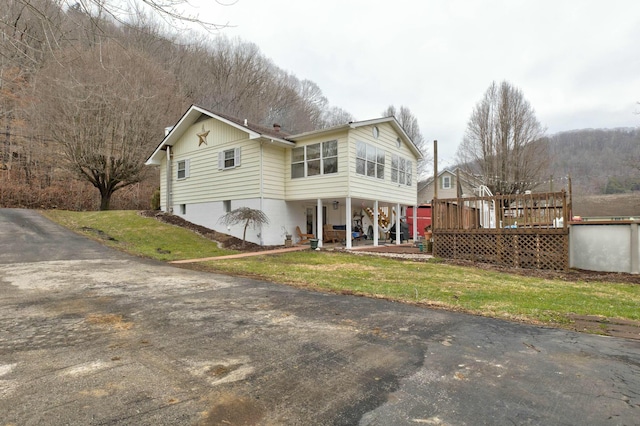 rear view of house with a wooden deck and a yard