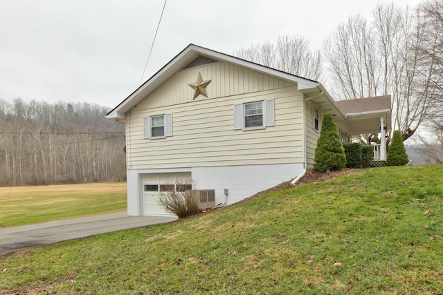 view of side of home featuring a garage and a yard