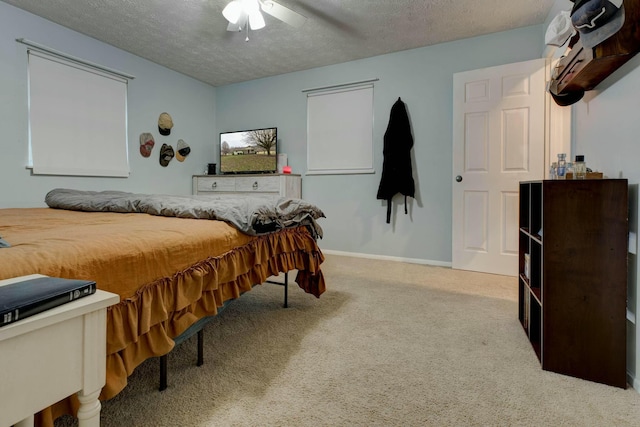 carpeted bedroom with ceiling fan and a textured ceiling