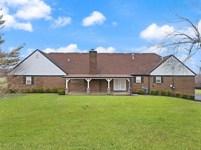 rear view of property with central air condition unit and a lawn