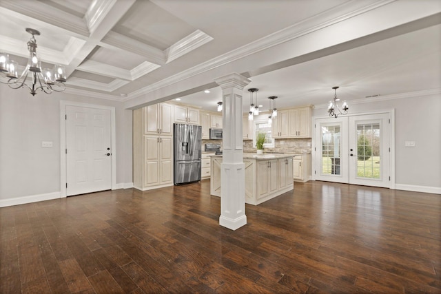 kitchen featuring tasteful backsplash, a kitchen island, a notable chandelier, pendant lighting, and stainless steel appliances