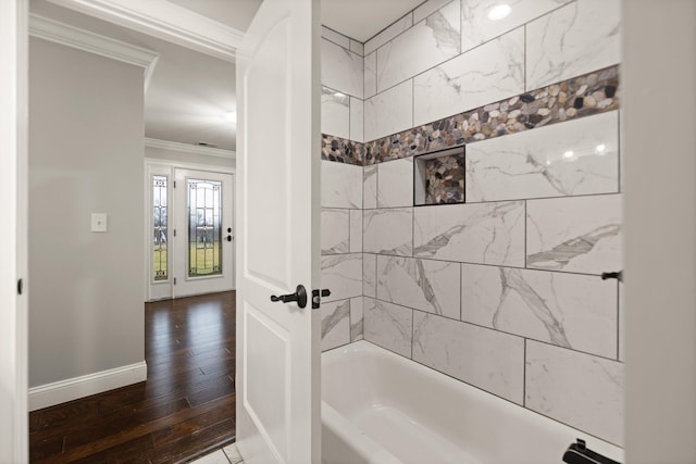 bathroom featuring crown molding, hardwood / wood-style floors, and tiled shower / bath