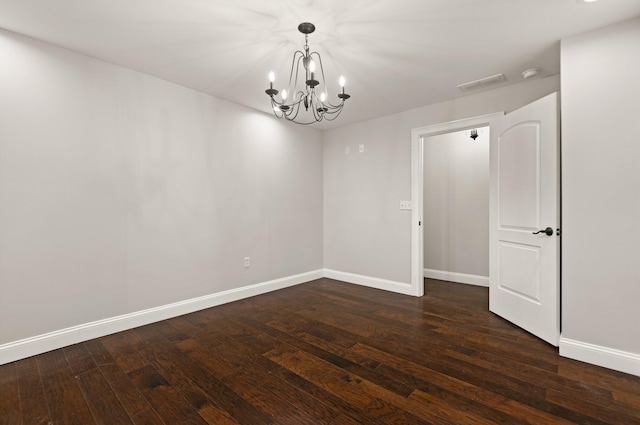 unfurnished room featuring dark hardwood / wood-style floors and a notable chandelier