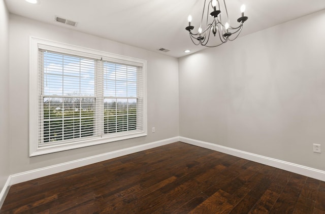 unfurnished room with hardwood / wood-style floors and a notable chandelier