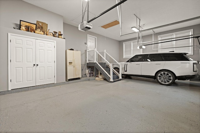 garage featuring a garage door opener and white fridge with ice dispenser