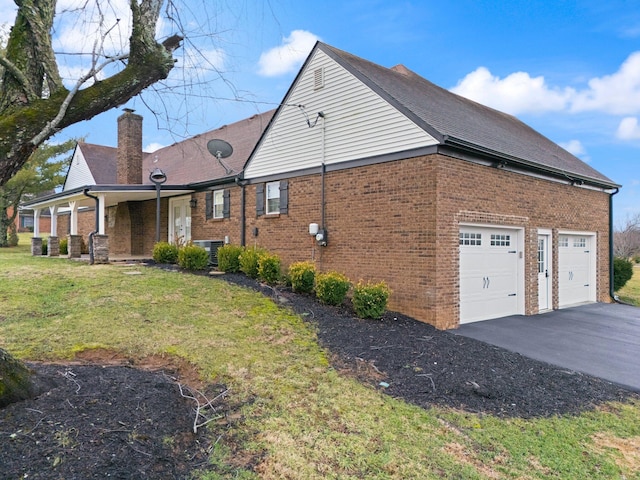 view of side of property with a garage and a lawn