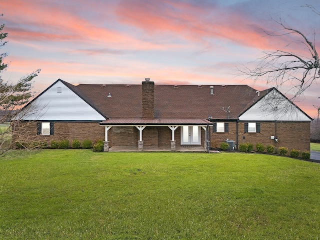 2940 Shakertown Rd, Danville, KY 40422 - back of property at dusk with a lawn, brick siding, a patio, and a chimney
