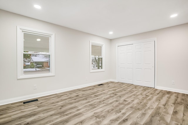 unfurnished bedroom featuring a closet and light wood-type flooring