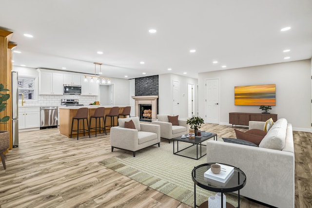 living room with a large fireplace and light hardwood / wood-style flooring