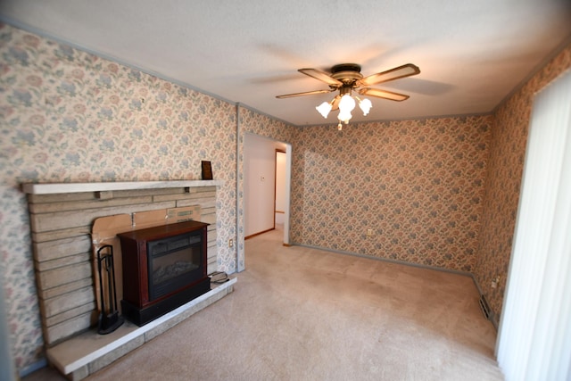 unfurnished living room with a stone fireplace, light colored carpet, and ceiling fan