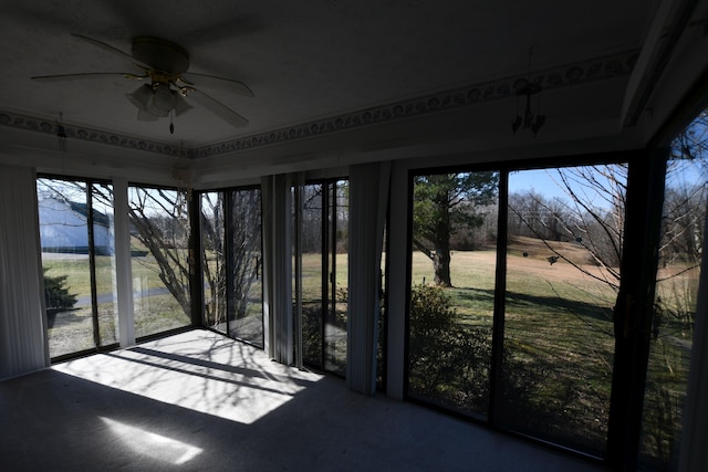 unfurnished sunroom featuring ceiling fan