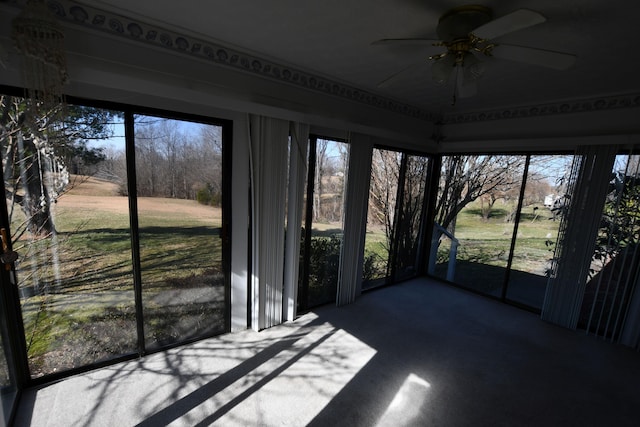 unfurnished sunroom with a wealth of natural light and ceiling fan