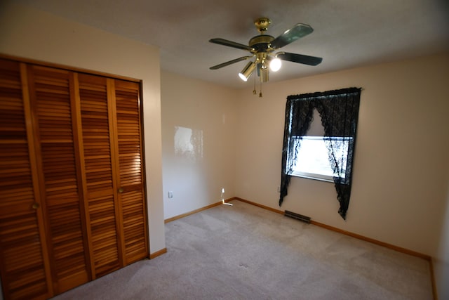 unfurnished bedroom featuring ceiling fan, light colored carpet, and a closet