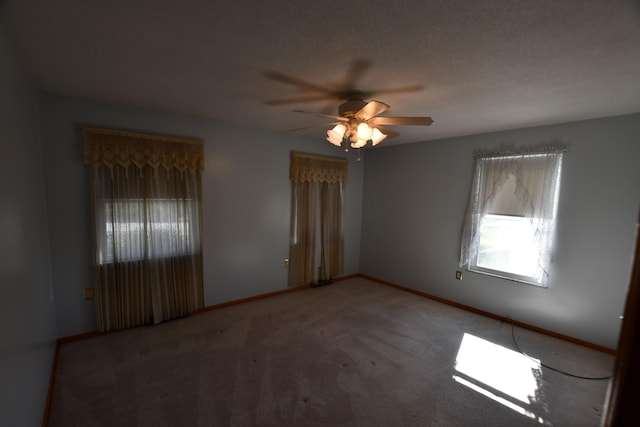 spare room featuring ceiling fan, carpet, and a textured ceiling