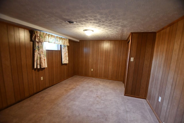 carpeted spare room featuring wooden walls