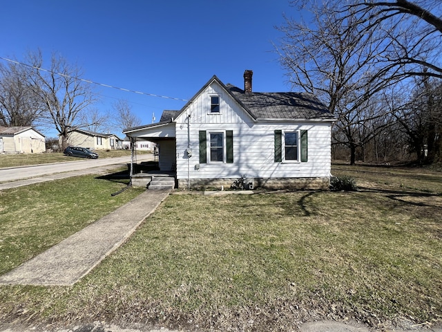 bungalow-style home with board and batten siding, a front yard, and a chimney