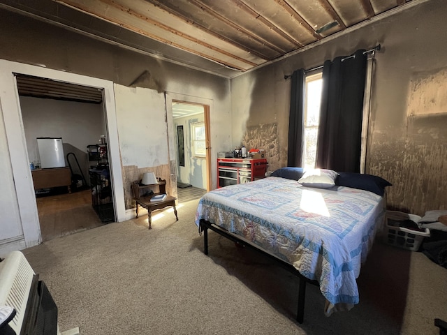 bedroom featuring ensuite bathroom, carpet, and heating unit