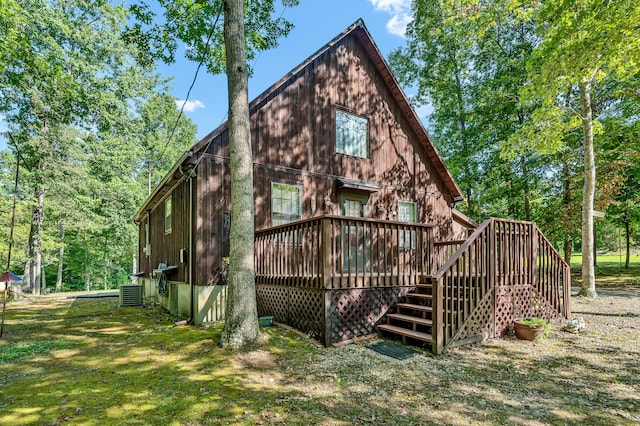 rear view of house featuring a deck, central AC, and a yard