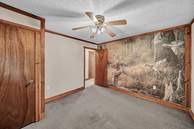 empty room featuring carpet floors, ceiling fan, a textured ceiling, and crown molding