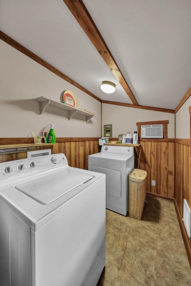 laundry area featuring a wainscoted wall, laundry area, separate washer and dryer, and wooden walls