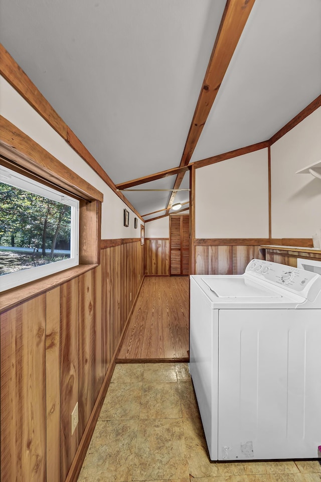 clothes washing area featuring laundry area, washer / clothes dryer, wainscoting, and wooden walls